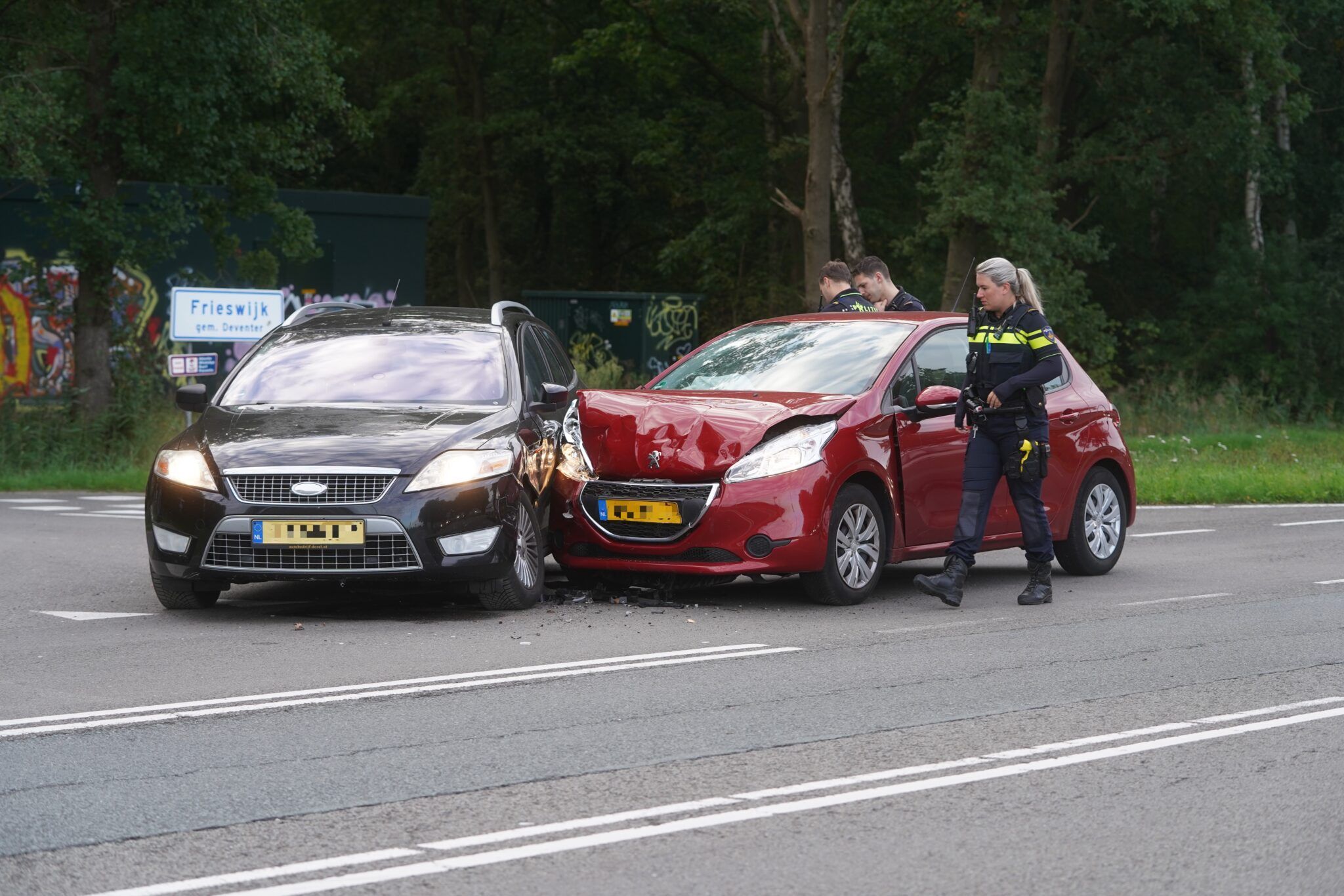 Aanrijding tussen twee personenauto's op Raalterweg Deventer; politie deelt knuffelbeertjes uit aan 